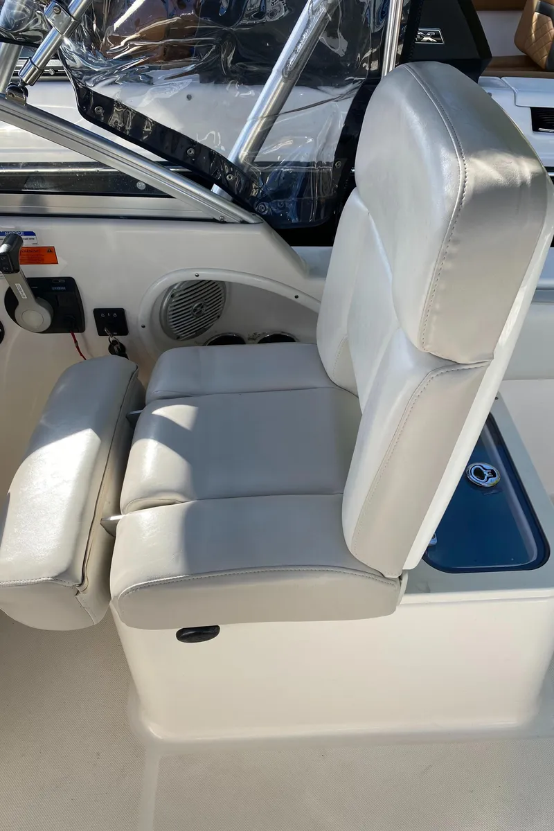 Slide: The Image of 2013 Pursuit DC 235 Dual Console boat seat with white upholstery. - 8
