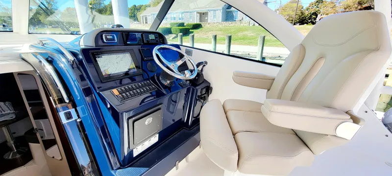 Slide: The Image of 2015 Pursuit OS 345 Offshore boat cockpit with steering wheel and navigation system. - 11