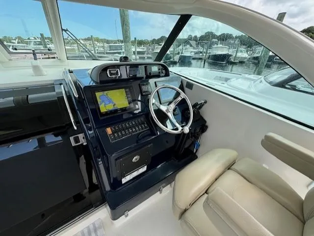Slide: The Image of 2015 Pursuit OS 345 Offshore boat cockpit with navigation system and steering wheel. - 12