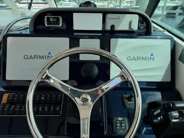 Slide: The Image of 2015 Pursuit OS 345 Offshore helm with Garmin navigation displays and controls. - 13