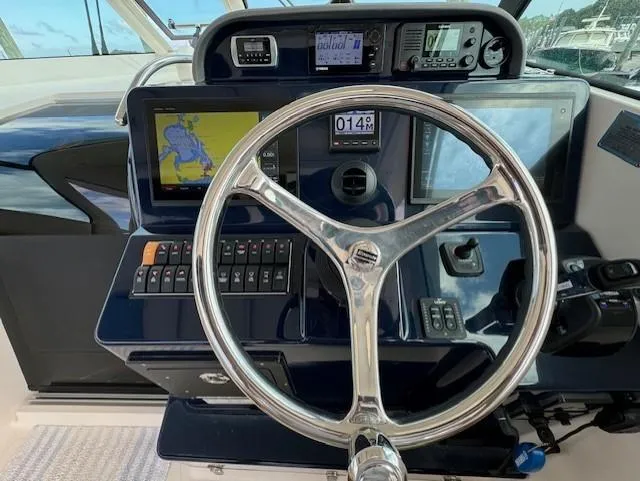 Slide: The Image of Steering wheel and dashboard of 2015 Pursuit OS 345 Offshore boat with navigation equipment. - 14