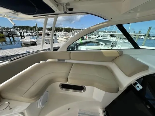 Slide: The Image of 2015 Pursuit OS 345 Offshore boat interior with beige seating at marina. - 16