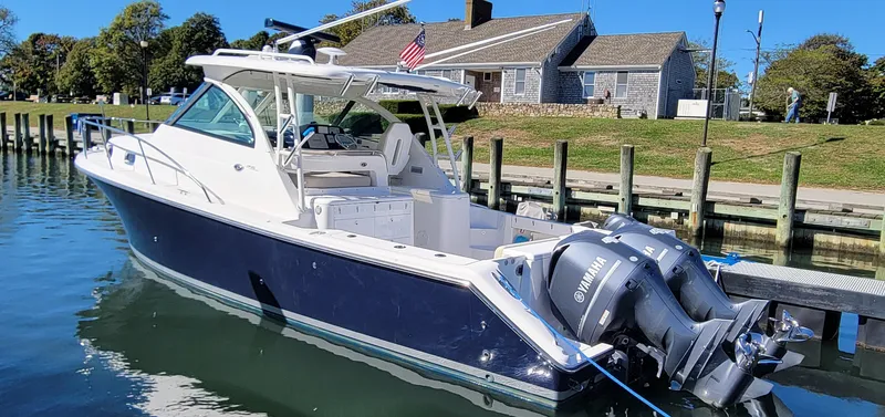 Slide: The Image of 2015 Pursuit OS 345 Offshore boat docked with twin Yamaha engines. - 2
