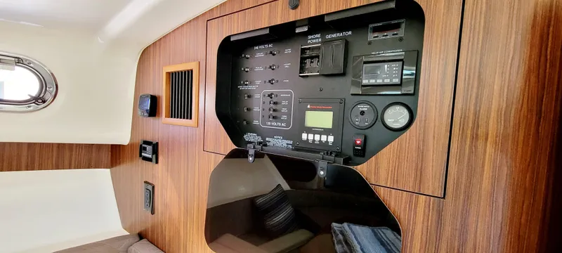 Slide: The Image of Control panel inside 2015 Pursuit OS 345 Offshore boat cabin, featuring wood paneling. - 21