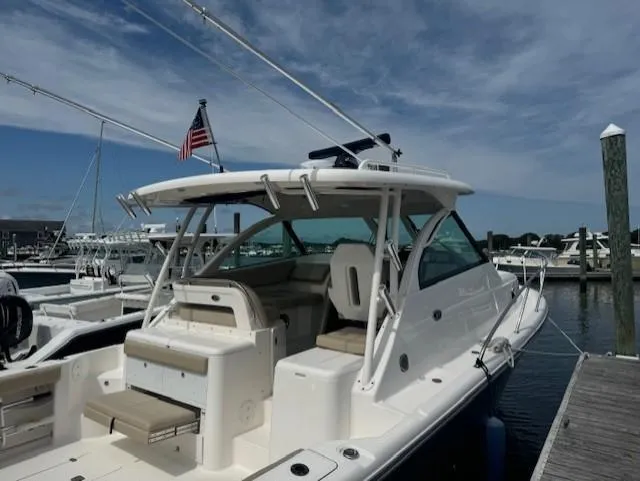 Slide: The Image of 2015 Pursuit OS 345 Offshore boat docked at marina under clear sky. - 3