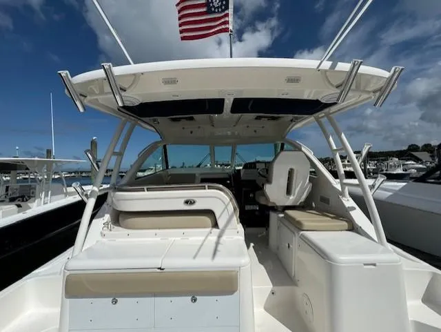 Slide: The Image of 2015 Pursuit OS 345 Offshore boat with American flag, docked under blue sky. - 4