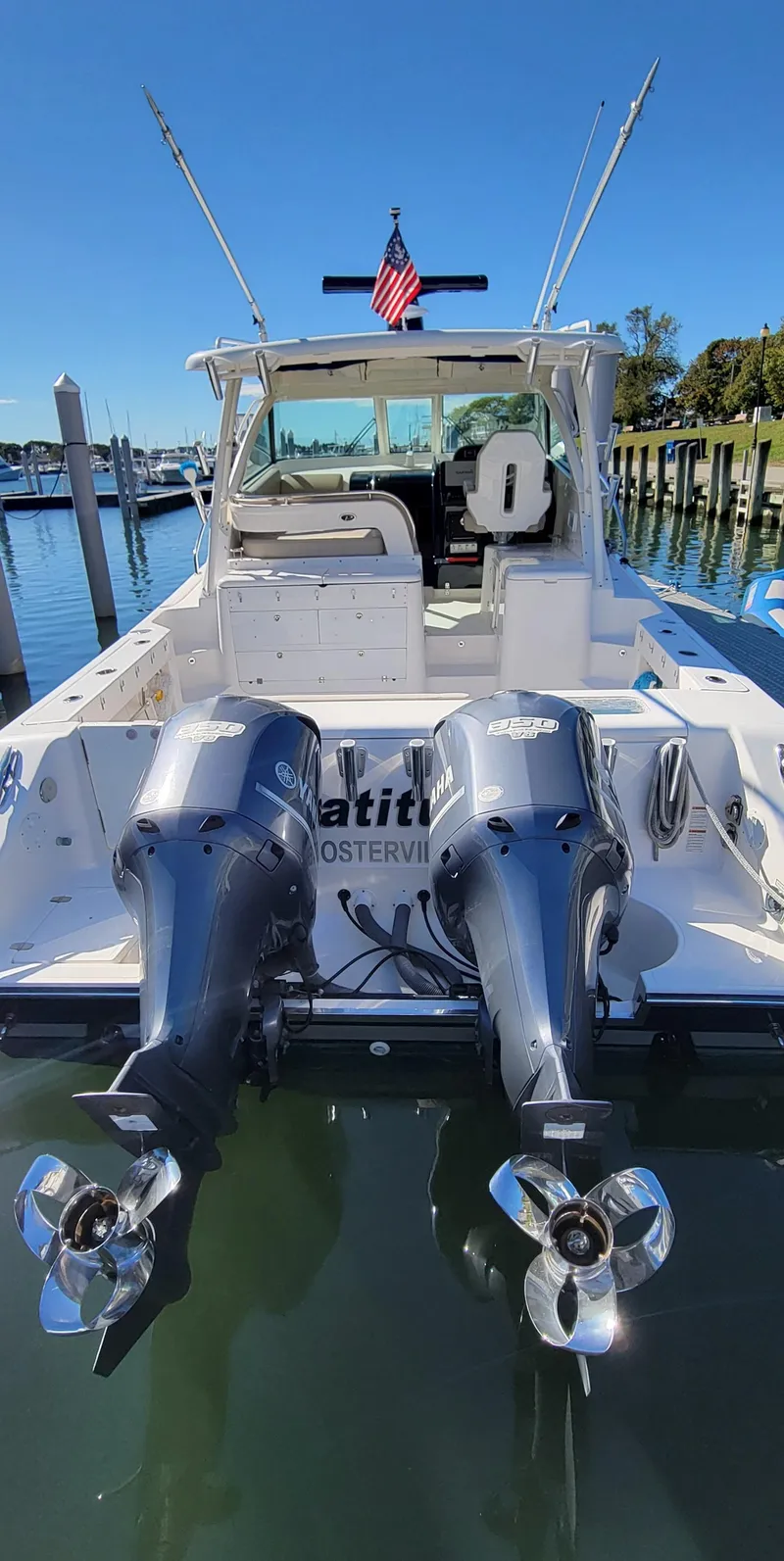 Slide: The Image of 2015 Pursuit OS 345 Offshore boat with dual outboard motors docked in marina. - 5