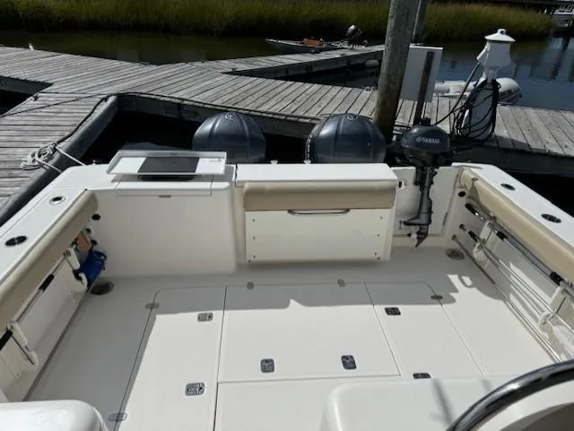 Slide: The Image of 2015 Pursuit OS 345 Offshore boat deck with dual engines at dock. - 7