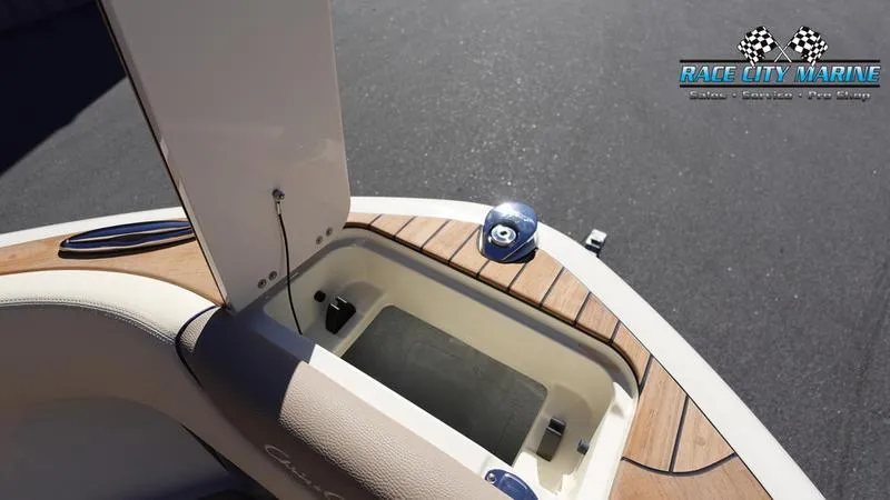 Slide: The Image of 2025 Chris-Craft Sportster boat interior with open storage compartment, Race City Marine logo. - 44