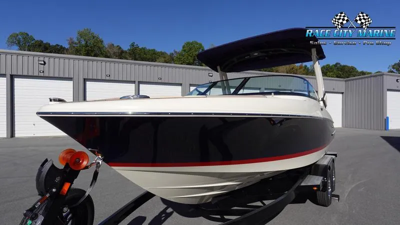 Slide: The Image of 2025 Chris-Craft Sportster boat on trailer, parked outside storage units. - 5