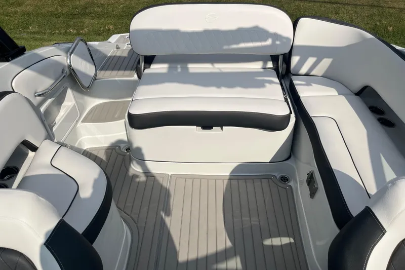 Slide: The Image of 2025 Crownline Eclipse E235 boat interior with white and black seating, spacious layout. - 13