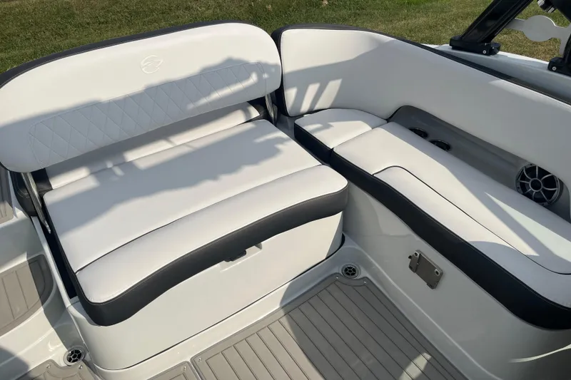 Slide: The Image of 2025 Crownline Eclipse E235 boat interior with white cushioned seating and speaker. - 16
