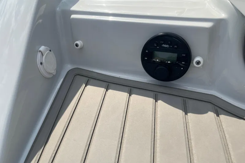 Slide: The Image of 2025 Crownline Eclipse E235 boat interior with audio controls and speaker on deck. - 18