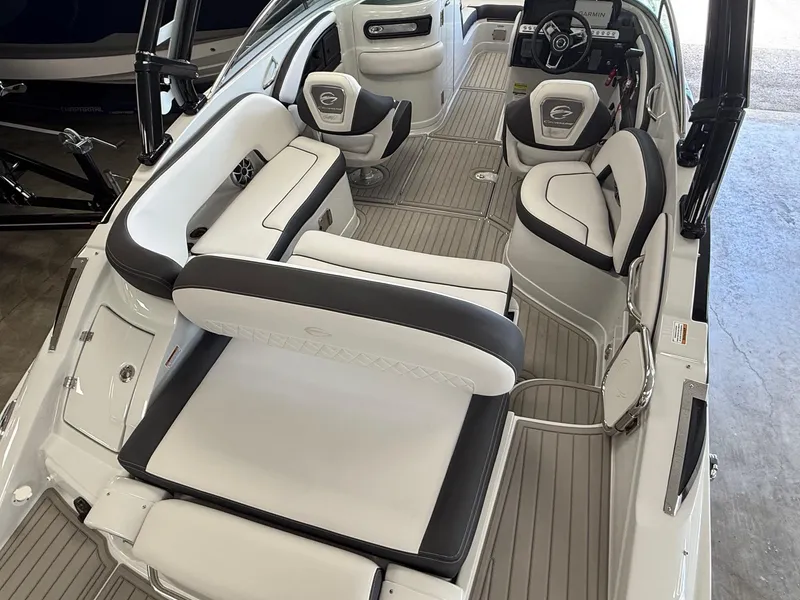 Slide: The Image of 2025 Crownline Eclipse E235 boat interior with Garmin displays and modern steering wheel. - 2