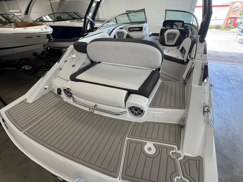 Slide: The Image of 2025 Crownline Eclipse E235 boat interior with white cushioned seating and built-in speakers. - 3