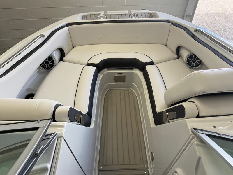 Slide: The Image of 2025 Crownline Eclipse E235 boat interior with white cushioned seating and built-in speakers. - 4