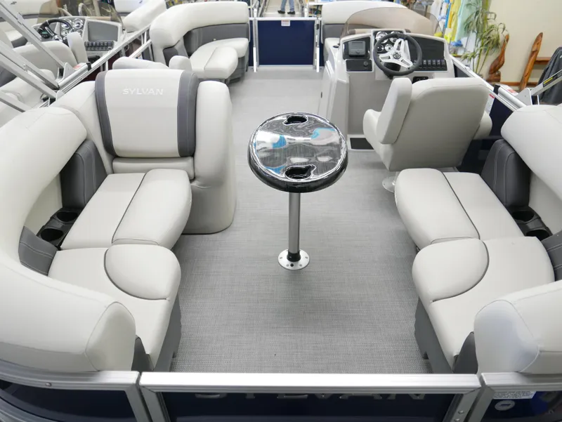 Slide: The Image of 2025 Sylvan Mirage 8520 LZ pontoon boat interior with plush seating and central table. - 19