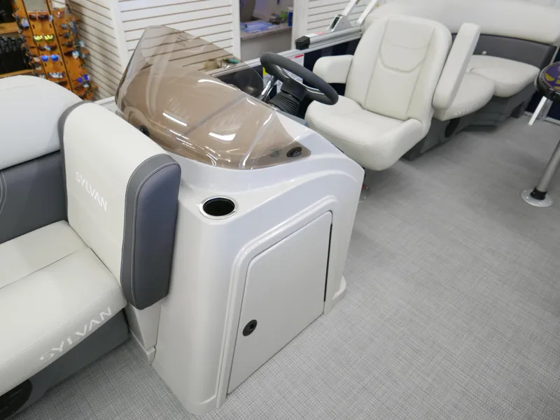 Slide: The Image of 2025 Sylvan Mirage 8520 LZ boat interior with steering console and seating. - 8