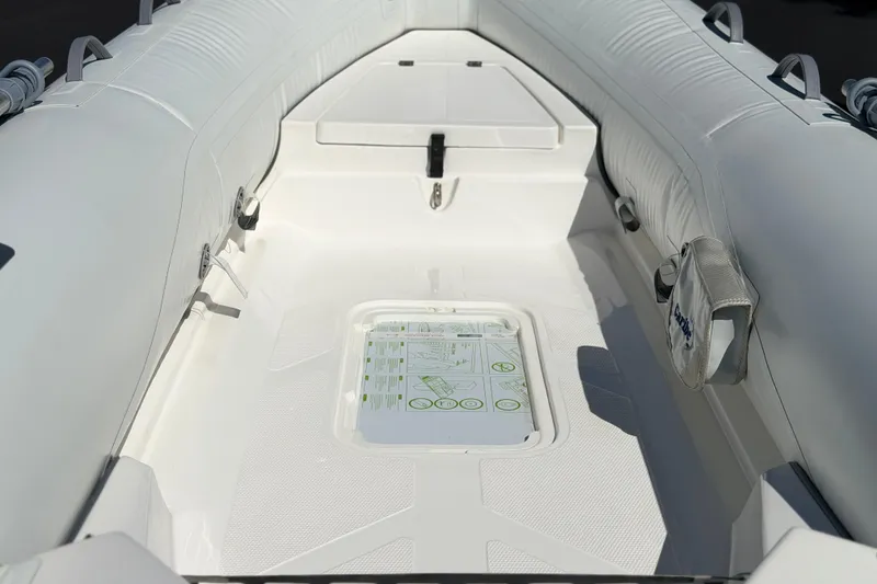 Slide: The Image of Interior view of a 2025 Caribe MVP11 inflatable boat, showcasing seating and storage. - 13
