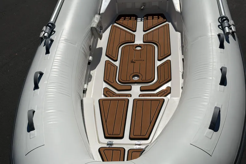 Slide: The Image of Inflatable boat interior, Caribe MVP11 2025 model, featuring brown deck panels. - 26
