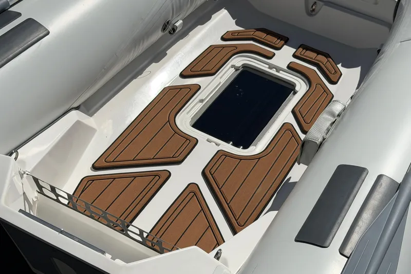 Slide: The Image of Interior view of 2025 Caribe MVP11 inflatable boat with wooden deck accents. - 32