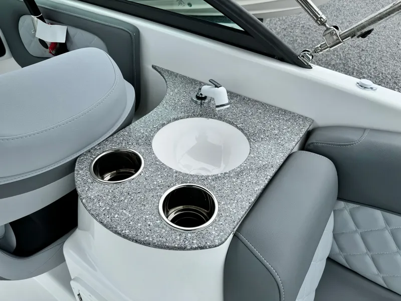 Slide: The Image of 2025 NauticStar 243 DC Deck boat interior with sink and cup holders. - 13