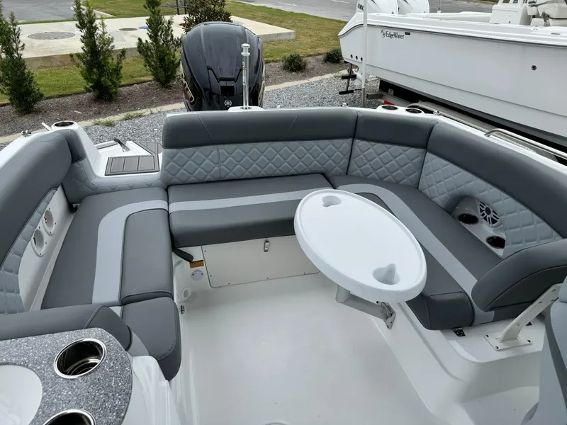 Slide: The Image of 2025 NauticStar 243 DC Deck boat with gray seating and table. - 14