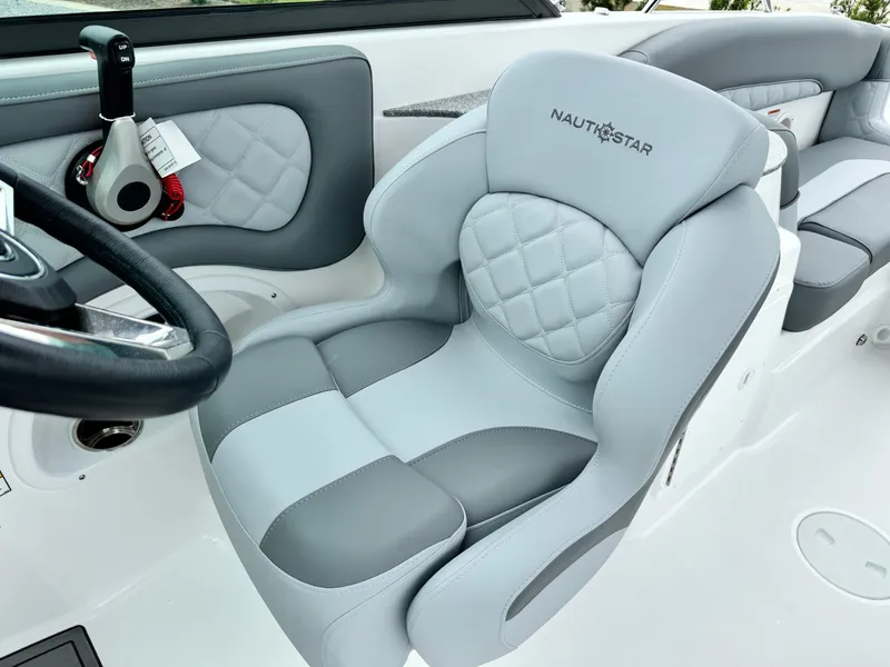 Slide: The Image of 2025 NauticStar 243 DC Deck boat interior with plush seating and modern design. - 18