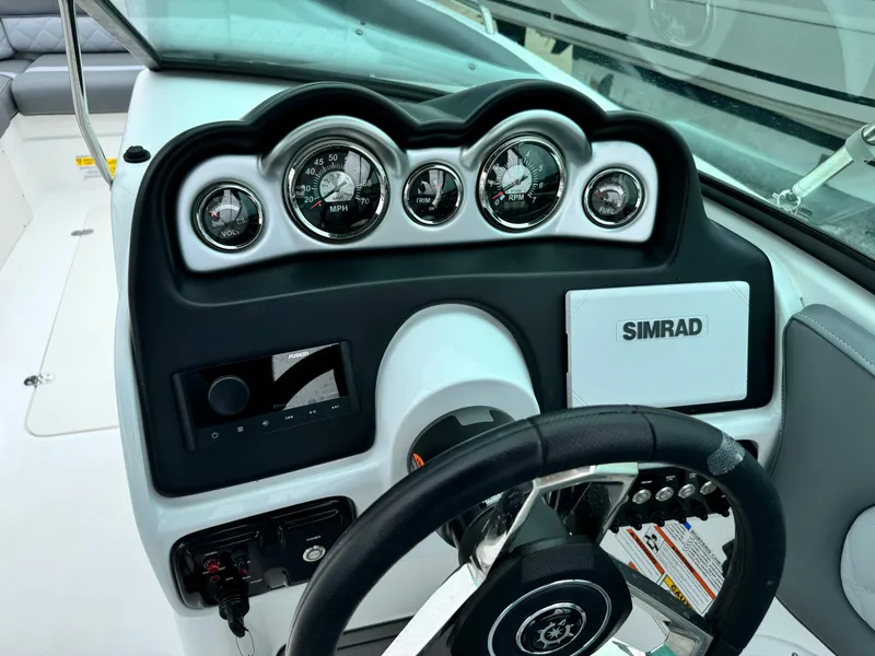 Slide: The Image of 2025 NauticStar 243 DC Deck boat dashboard with Simrad display and gauges. - 19
