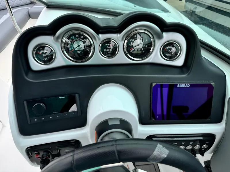 Slide: The Image of 2025 NauticStar 243 DC Deck boat dashboard with gauges and Simrad display. - 21