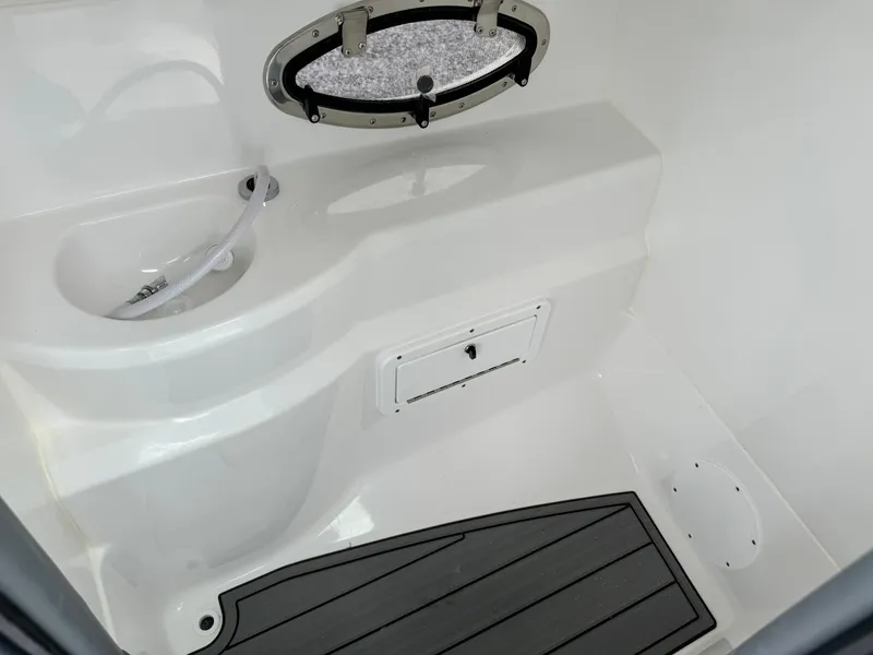 Slide: The Image of 2025 NauticStar 243 DC Deck boat interior with sink and storage compartment. - 25