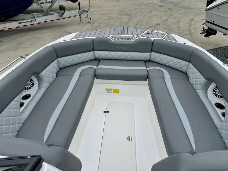 Slide: The Image of 2025 NauticStar 243 DC Deck boat with spacious gray seating and modern design. - 27