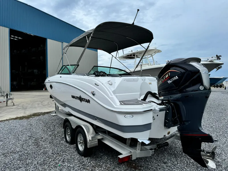 Slide: The Image of 2025 NauticStar 243 DC Deck boat on trailer with Yamaha outboard motor. - 3