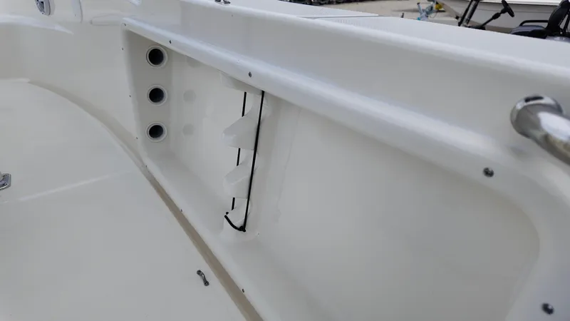 Slide: The Image of 2025 Bulls Bay 200CC boat interior detail with rod holders and storage compartment. - 8