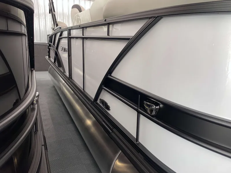 Slide: The Image of 2025 Sylvan L1 LZ pontoon boat with Mercury 115HP engine, sleek design in showroom. - 1