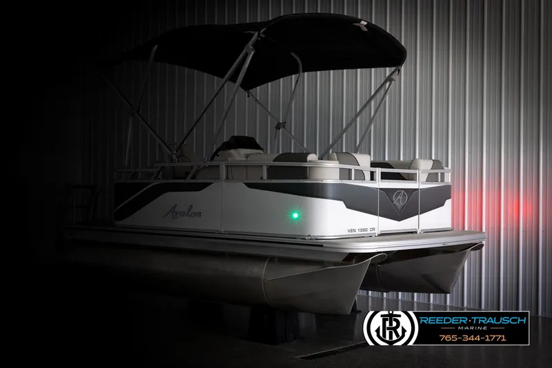 Slide: The Image of 2025 Avalon VENT CR pontoon boat in a dimly lit showroom. - 4