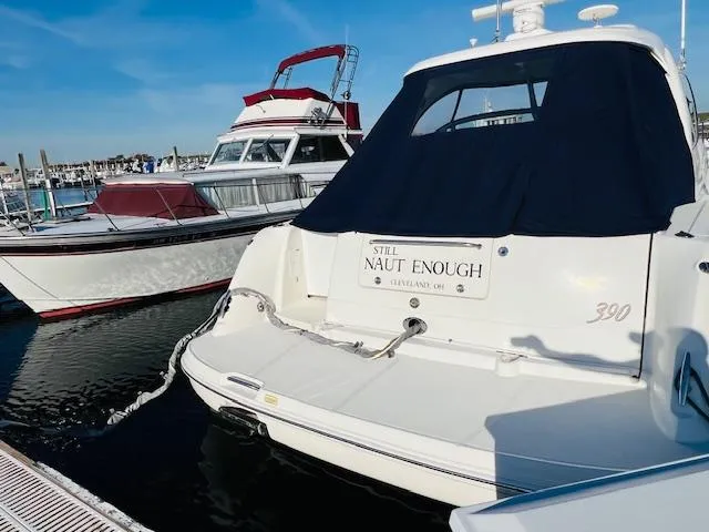 Slide: The Image of 2004 Sea Ray 390 Sundancer docked at marina, rear view with cover. - 3