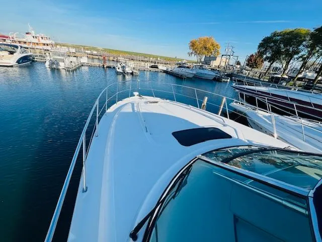 Slide: The Image of 2004 Sea Ray 390 Sundancer yacht docked in a marina under clear blue skies. - 4