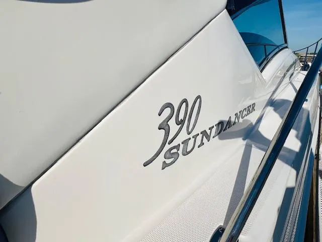 Slide: The Image of 2004 Sea Ray 390 Sundancer yacht, sleek design with logo detail. - 6