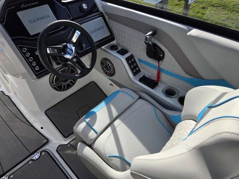 Slide: The Image of 2025 Hurricane SunDeck 2600 OB boat interior with Garmin navigation, steering wheel, and seating. - 23