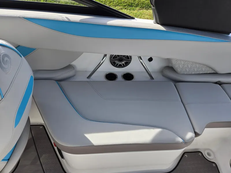 Slide: The Image of 2025 Hurricane SunDeck 2600 OB interior seating with blue accents and speaker system. - 25