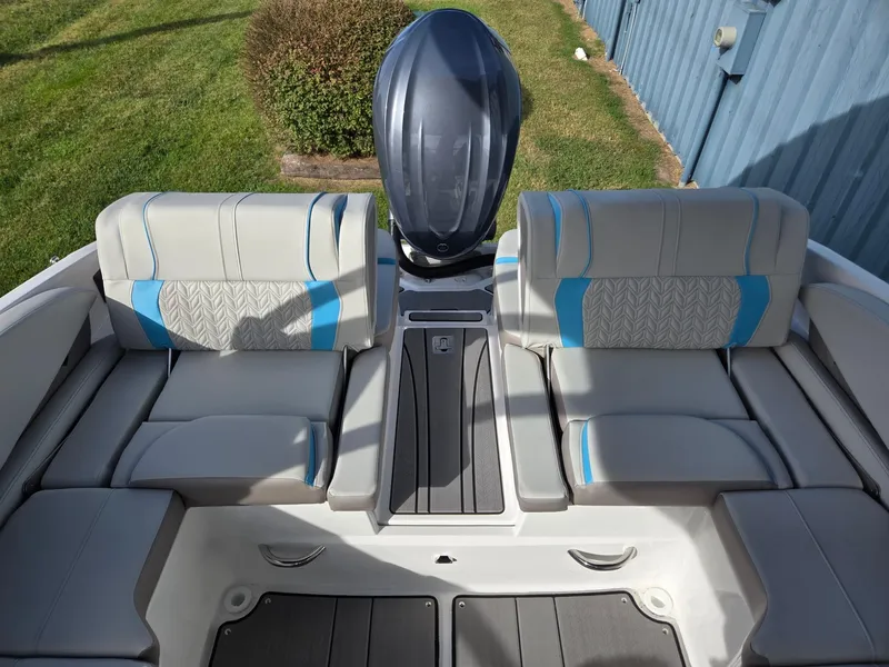 Slide: The Image of 2025 Hurricane SunDeck 2600 OB boat interior with cushioned seating and outboard motor. - 27
