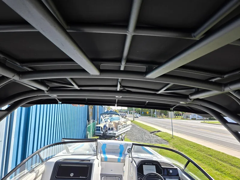 Slide: The Image of 2025 Hurricane SunDeck 2600 OB boat interior with canopy and dashboard view. - 32