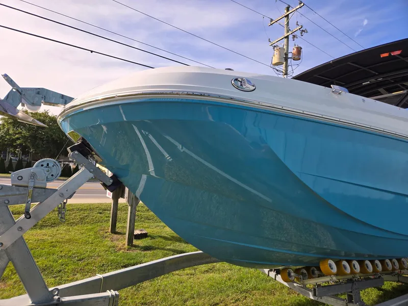 Slide: The Image of 2025 Hurricane SunDeck 2600 OB boat on trailer, vibrant blue hull, sunny day. - 8