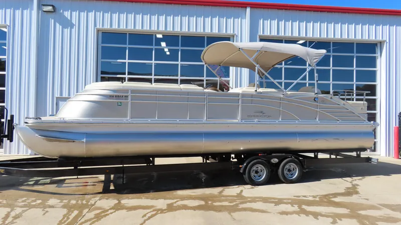 The Image of 2013 Bennington 2875 QCW I/O pontoon boat on trailer, parked outside a garage. - 0