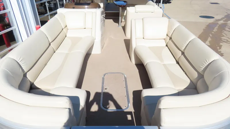 Slide: The Image of 2013 Bennington 2875 QCW I/O boat interior with beige seating and spacious layout. - 11