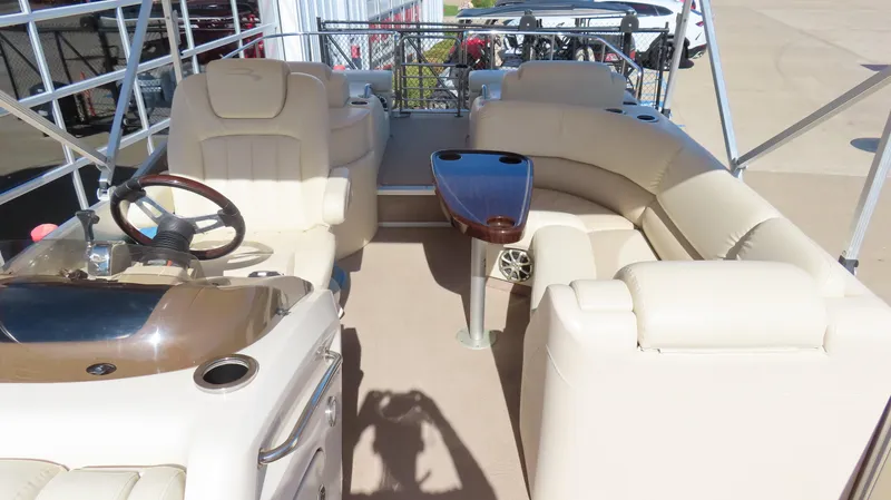 Slide: The Image of 2013 Bennington 2875 QCW I/O boat interior with beige seating and steering console. - 13