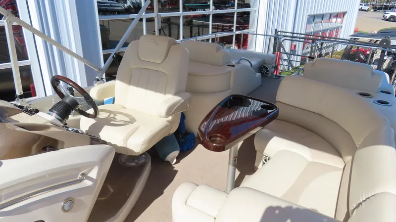 Slide: The Image of 2013 Bennington 2875 QCW I/O boat interior with beige seating and steering wheel. - 15
