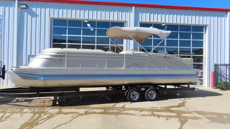 Slide: The Image of 2013 Bennington 2875 QCW I/O pontoon boat on trailer outside a garage. - 18