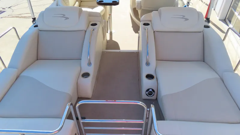 Slide: The Image of 2013 Bennington 2875 QCW I/O boat interior with beige seating and cup holders. - 19